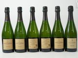 six bouteilles de vin sont alignées sur une table