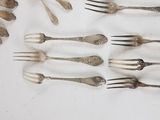a lot of forks and spoons that are on the table