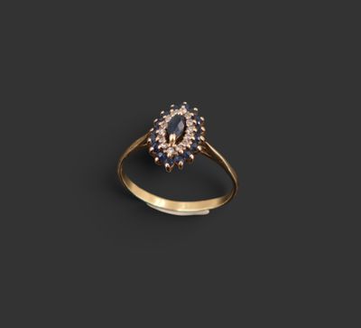 une bague en or sertie d'un saphir ovale entouré de petits diamants blancs