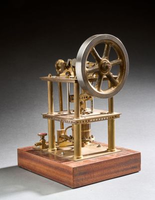une vieille maquette de machine à vapeur posée sur un socle en bois