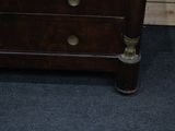 a small wooden chest of drawers with a mirror on top of it