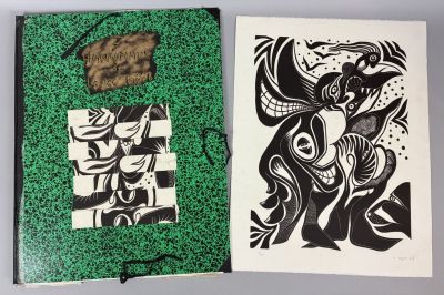 two books with black and white drawings on them sitting on a table