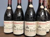 six bottles of red wine are lined up on a wooden table