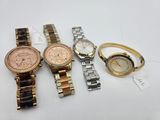 three watches and a ring on a table with a price tag