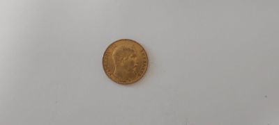 une pièce d'or posée sur une surface blanche