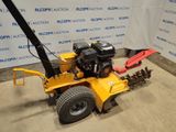 an image of a yellow lawn mower parked in front of a wall