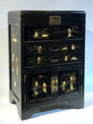 une commode noire surmontée de nombreux tiroirs