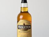 une bouteille de whisky irlandais Midleton posée sur une table en bois