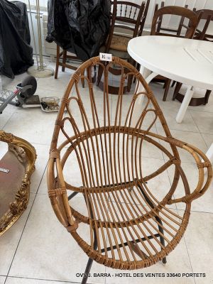 a wicker chair that is sitting in the middle of a room