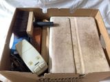 a box with a brush, a brush, and other items in it