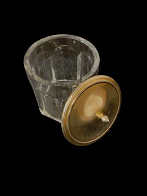 un verre avec un couvercle doré sur fond noir