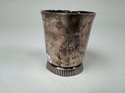 une coupe en argent posée sur une table blanche