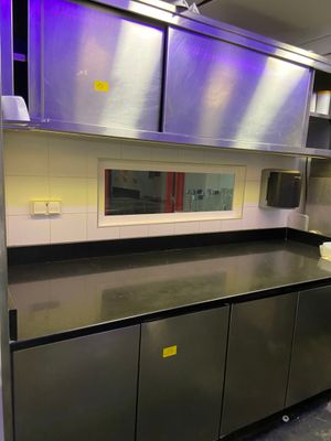 une cuisine avec des placards en inox et des plans de travail noirs