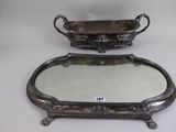 two silver trays with handles and a mirror on a table