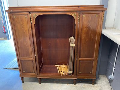 a wooden cabinet with a door and a book shelf