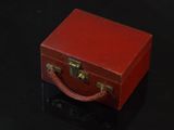 une petite valise rouge posée sur une table noire