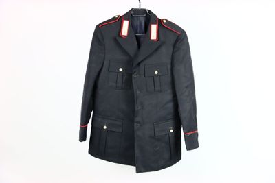 une photo d'un manteau militaire noir accroché à un mur blanc
