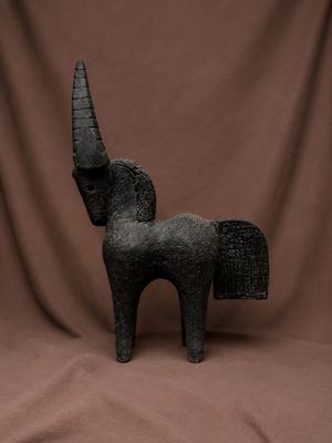 sculpture représentant un cheval doté d'une longue corne, sur fond marron