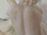 a statue of a woman sitting on a bed