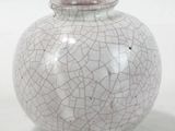 un vase blanc et rose orné d'un motif craquelé
