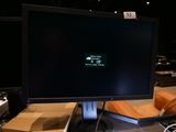 un écran d'ordinateur posé sur un bureau à côté d'un clavier