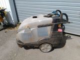 an image of a dirty cleaning machine in front of a garage