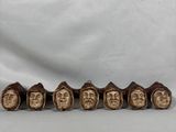 un ensemble de cinq têtes d'hommes en bois coiffées de chapeaux