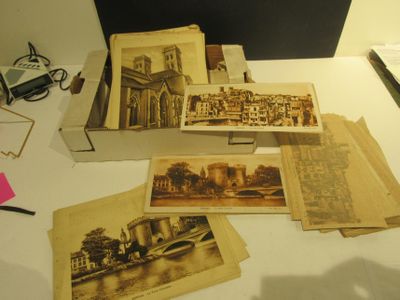 de nombreuses vieilles photos posées sur une table, à côté d'un ordinateur portable