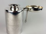 silver plated coffee pot with handle and spoon on white background