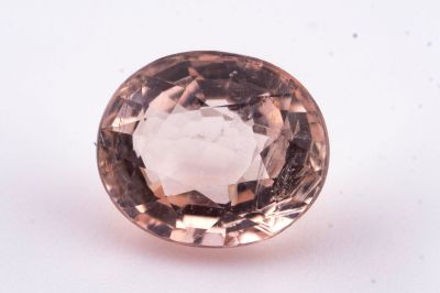 un gros plan d'un diamant rose sur une surface blanche
