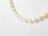 a close up of a pearl necklace on a mannequin mannequin