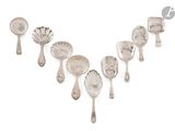 six cuillères en argent et des cuillères à soupe posées sur une surface blanche