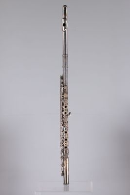 an image of a silver flute on a clear stand on a gray background