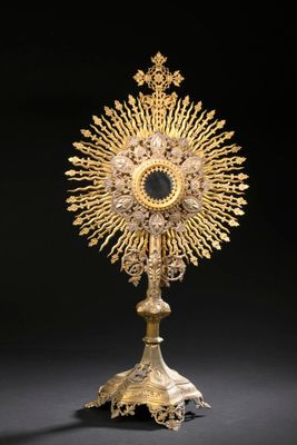 un plat en or richement décoré, surmonté d'une croix