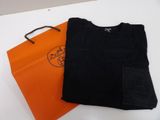 black t - shirt and orange bag sitting on a white table