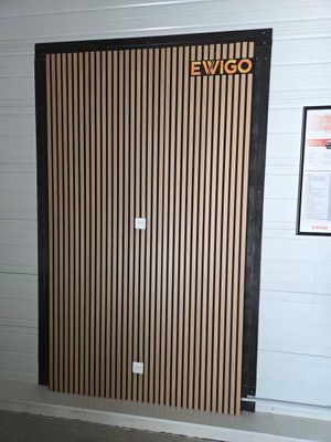 une porte en bois sur laquelle est accrochée une pancarte portant l'inscription « ewigo »