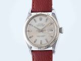 a close up of a wrist watch with a red leather strap
