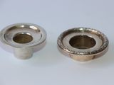 deux bougeoirs en argent posés sur une table blanche