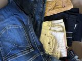 several pairs of jeans are stacked on top of each other