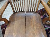 an old wooden chair sitting on a rug in a room
