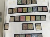 un livre ouvert avec un tas de timbres posé sur une table