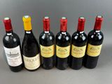 six bottles of wine are lined up in a row on a table