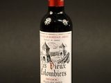 a bottle of red wine sitting on top of a black table