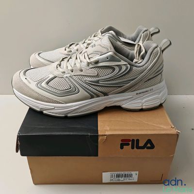 des chaussures Fila dans une boîte posée sur une table