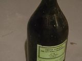 a black bottle with a green label sitting on a table