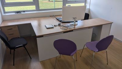 un bureau avec deux chaises et un ordinateur dessus