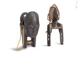 pair of african carved wooden chairs with a rope on the back of the chair