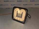 un gros plan sur une lampe posée sur une table, avec un mur en arrière-plan