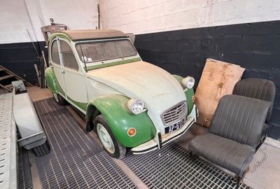 a green and white car sitting in a garage