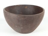 a wooden bowl that is sitting on a white surface